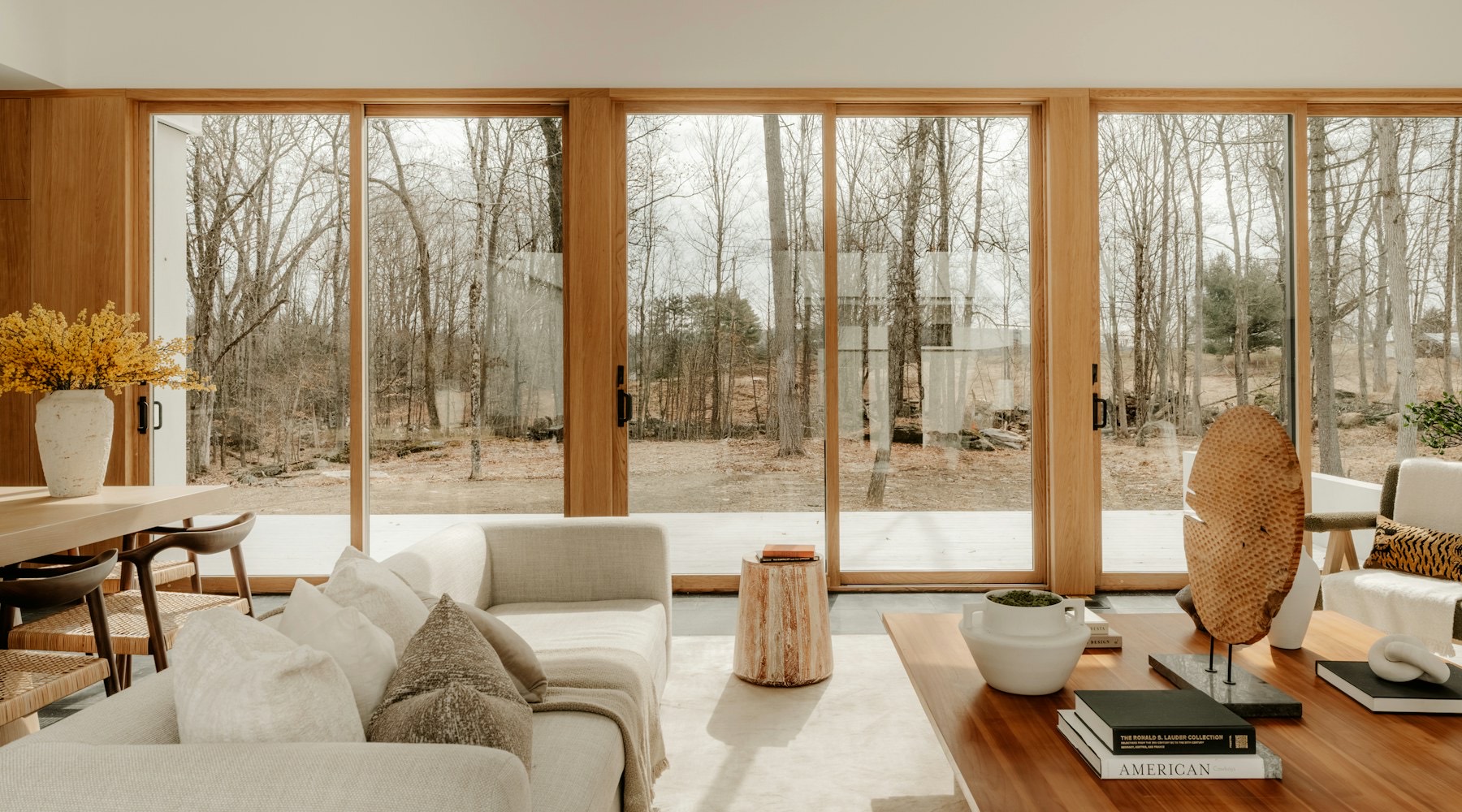 Moderne woonkamer met een brede schuifpui en uitzicht op de tuin
